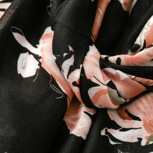 Détail macro d'une écharpe en coton et lin avec motif floral et tissage chevron