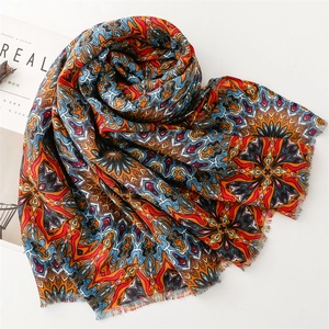 Detail of bohemian scarf with vibrant mandala pattern and raw edge fringe design