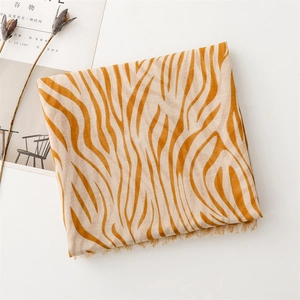 Detail view of orange zebra print scarf with frayed edges and lightweight fabric texture