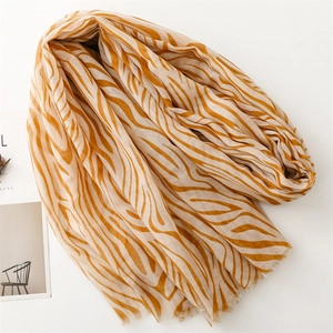 Detail of thin yellow zebra print scarf featuring delicate frayed fringe edges