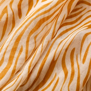 Detailed macro view of sheer bali gauze fabric with vibrant yellow zebra print texture