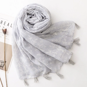 Light gray Bali gauze scarf with white floral embroidery and tassel details for sun protection