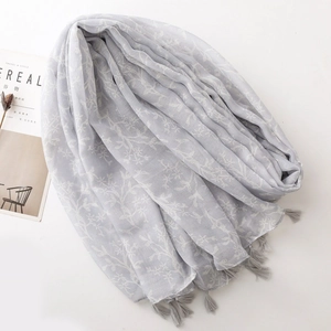 Close-up of light grey-purple pashmina with white floral prints and fringe tassels