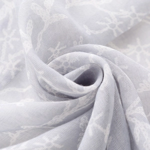 Light blue voile scarf with elegant white floral print and soft tassels for sun protection