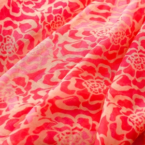 Close-up of floral print on thin voile scarf with vibrant red and pink flower patterns
