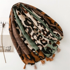 Detailed view of green leopard print scarf with delicate fringe edges and linen texture