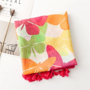 Close-up of vibrant butterfly print scarf with bright fuchsia tassels and soft bali yarn