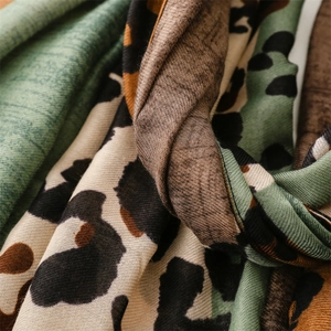 Close-up of green leopard print scarf fabric showing soft cashmere texture and fine weave