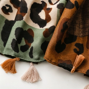 Macro detail of twill fabric leopard print scarf with fine fringe tassels in green and brown