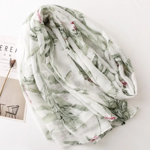 Detail of thin Bali yarn scarf with tropical green leaves and pink floral print texture