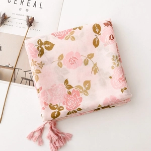Détail de l'imprimé floral rose sur écharpe texturée avec des franges élégantes