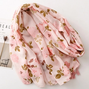 Écharpe en coton et lin rose avec motifs floraux et pompons sur fond blanc pur
