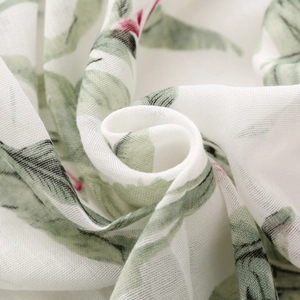 Close-up of tropical green leaf print on lightweight white semi-transparent scarf fabric