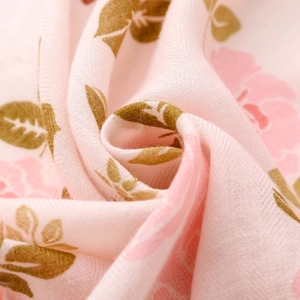 Gros plan du tissu d'écharpe rose à fleurs montrant une texture douce en coton et lin