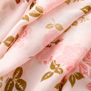 Gros plan sur les motifs de roses roses et la texture de fibre d'une écharpe douce