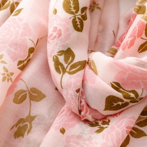 Détail du motif de roses roses et texture douce de l'écharpe en coton et lin