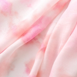 Close-up of pink watercolor ink gradient on soft cotton linen scarf with frayed edges