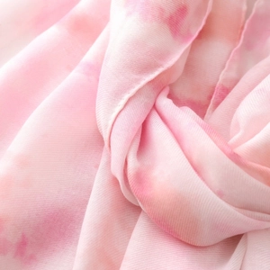 Detail of pink and white gradient tie-dye fabric showing soft texture and fine weave