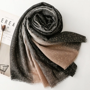 Detail of gradient shawl with gold foil sparkles and frayed edges on magazine background