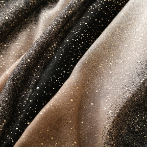 Close-up of linen-feel scarf fabric with gold foil speckles and gradient color transition