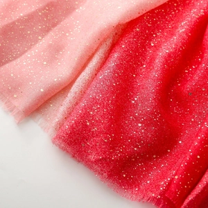 Detail of pink gradient scarf with gold foil accents and soft frayed edge texture