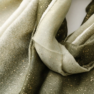 Macro shot of gradient linen-feel scarf with gold foil dots and frayed edge texture