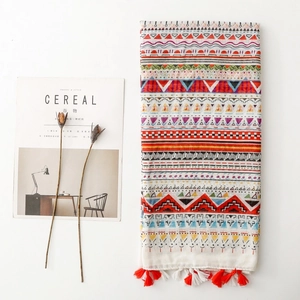 Bohemian style scarf with colorful geometric patterns and decorative tassels on white background