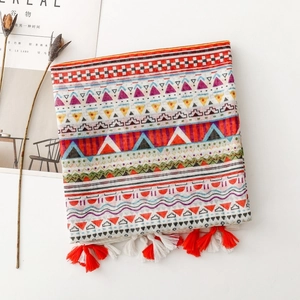 Detail of colorful bohemian scarf with geometric prints and fringe on white background