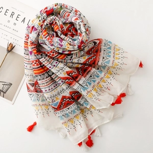 Close-up of bohemian shawl with ethnic geometric prints and red-white tassel details
