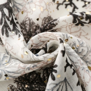 Detail of coral branch patterns with gold foil dot stamping on soft linen feel fabric