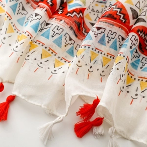 Detailed close-up of Bohemian geometric pattern and red tassels on cotton linen scarf