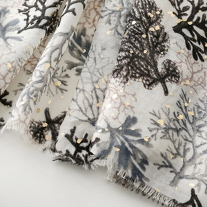Detail of coral pattern linen-feel scarf with gold foil dots and frayed edges