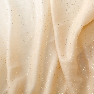 Macro detail of soft beige cotton linen scarf with elegant gold foil gradient pattern