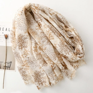 Detail of coral gold foil pattern and fine fringes on a linen-touch shawl scarf