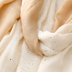 Detail view of cotton linen feel scarf featuring gold foil gradient and soft frayed edges