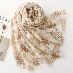 Detail of coral pattern scarf with gold foil accents and natural fringe edges