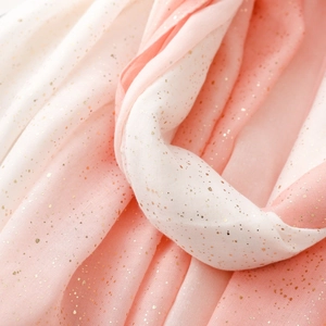 Macro detail of pink-white gradient scarf with gold foil dots and soft sheer fabric texture