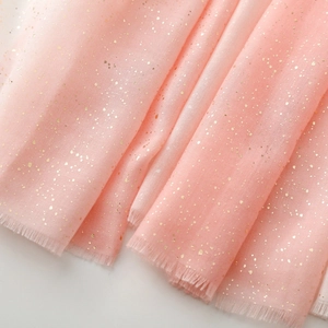 Close-up of pink linen scarf with gold foil accents and delicate frayed tassel edges