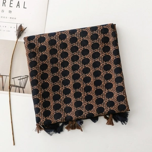 Detailed view of bohemian voile scarf with large polka dots, leopard print, and tassels