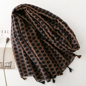 Close-up of leopard print scarf with fringe details on a minimalist aesthetic background