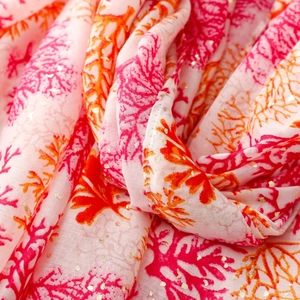 Detail of coral print scarf with gold foil accents and soft cotton linen texture