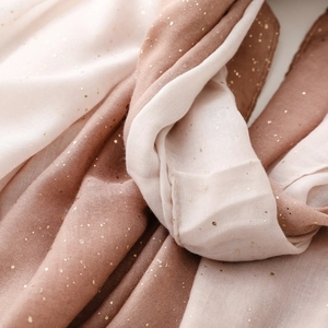 Close-up of cotton-linen feel scarf with gradient beige and gold bronzing detail