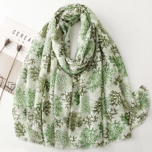 Detail view of light beige linen-feel scarf with green coral pattern and gold foil accents