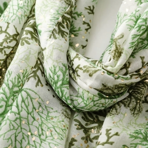 Detail of coral print scarf with gold foil accents on premium cotton linen fabric