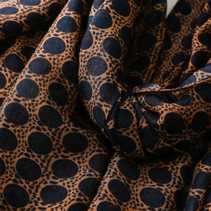 Detailed close-up of breathable navy voile scarf with brown honeycomb pattern texture