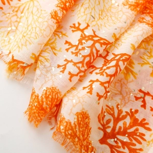 Detail of coral print scarf with gold foil accents and natural fringed edges