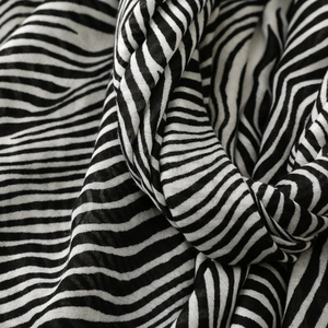 Detailed macro view of black and white zebra print scarf with fine woven texture and soft folds