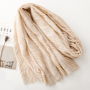 Detail of soft wave striped scarf with delicate fringe edges and light fabric texture