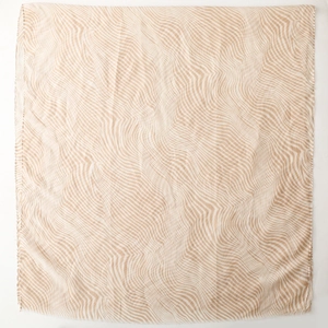 Flat lay of a large beige zebra pattern scarf with soft fringed edges on white background