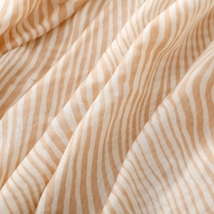 Macro shot of zebra pattern satin scarf fabric showing soft texture and beige wavy lines
